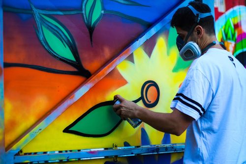 Artist spray painting flowers (Unsplash) — Spray Paint Art